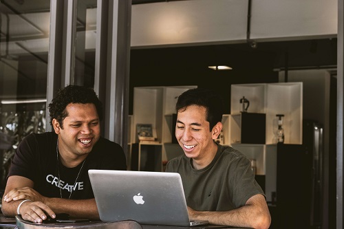 Photo of 2 men viewing a laptop