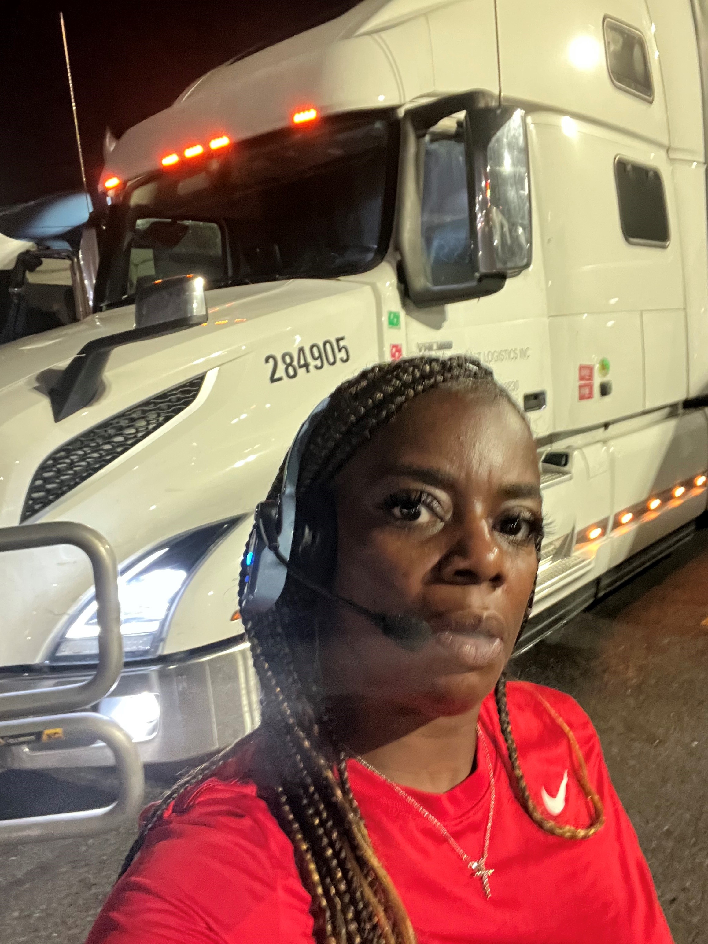 Jenill Coats posing for a photo in front of a truck.