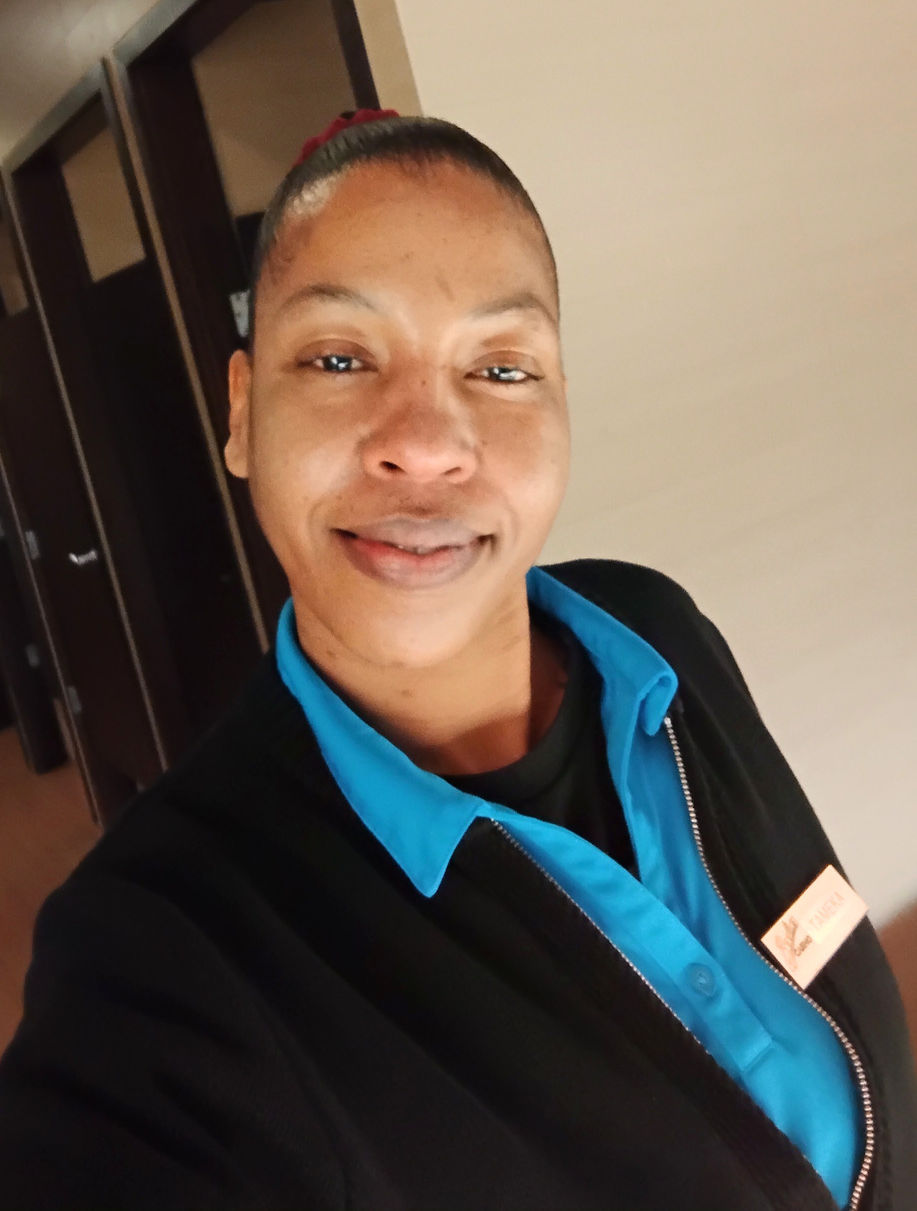 woman in blue collar shirt and black jacket look at camera