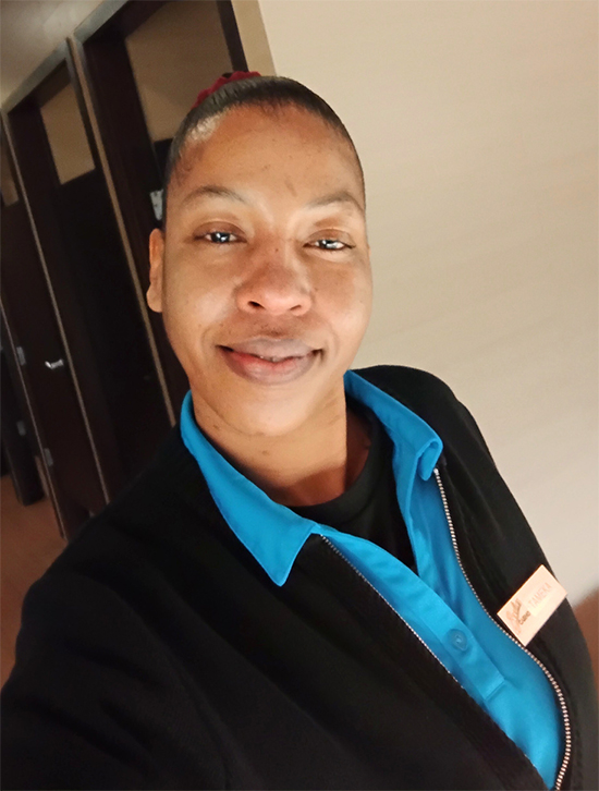 Woman in blue collar shirt and black jacket look at camera